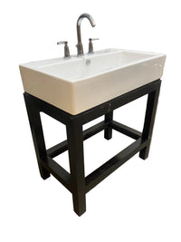 Rectangular white ceramic bathroom sink mounted on a black wooden base