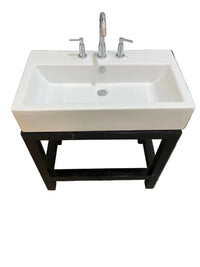 Rectangular white ceramic bathroom sink mounted on a black wooden base