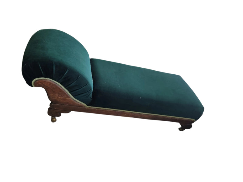 A vintage- style chaise lounge with green velvet