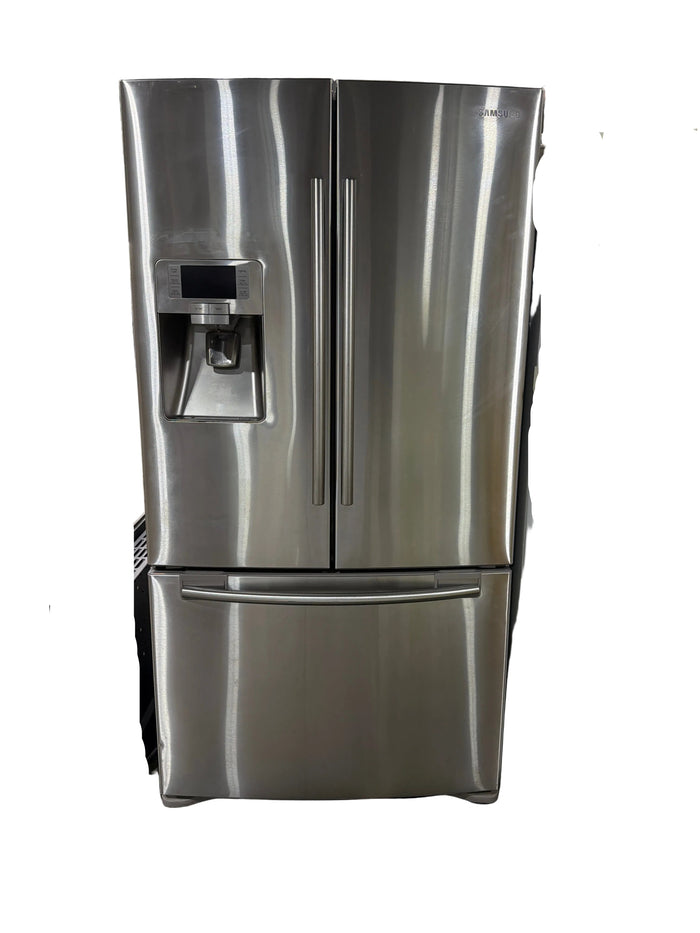 A stainless steel side-by-side refrigerator with a water and ice dispenser on the lower left door, photographed in what appears to be a showroom or warehouse setting.