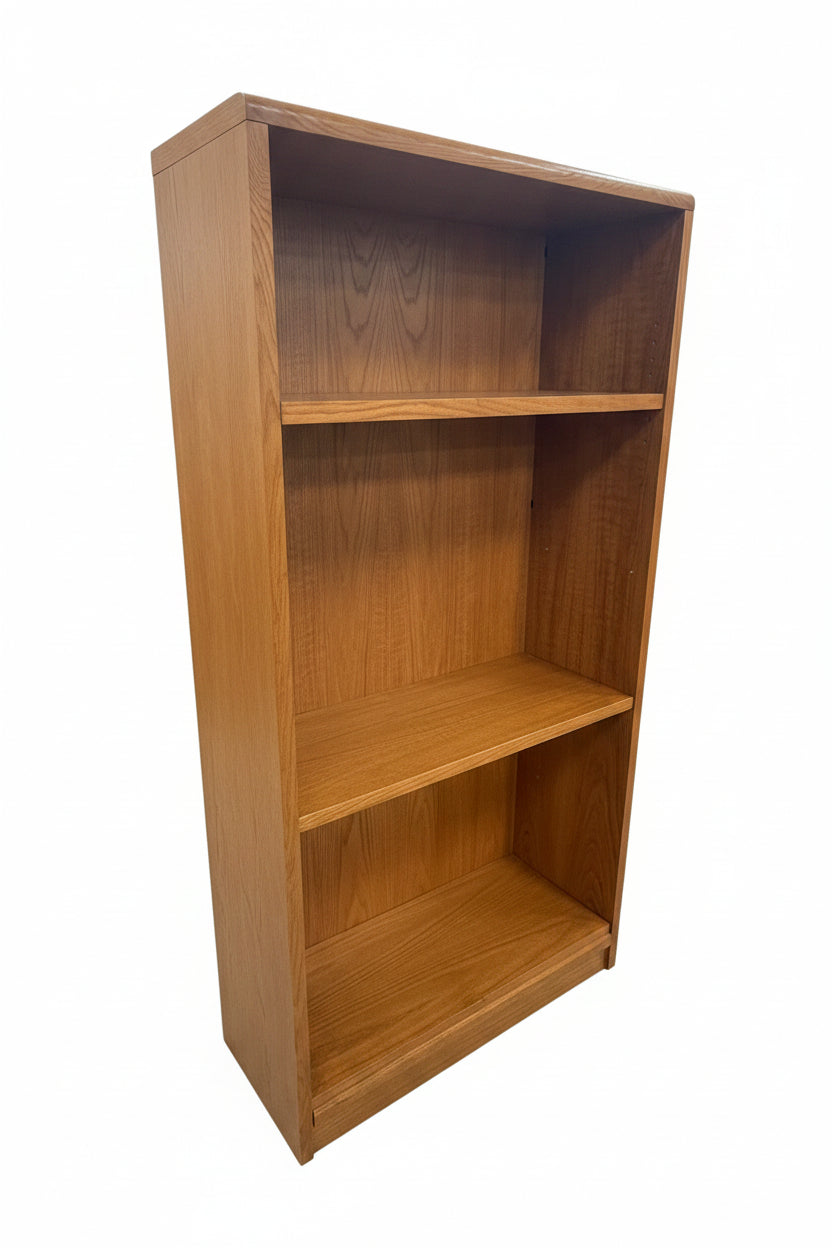 A tall wooden bookshelf with three open shelves, shown next to a matching wooden cabinet in a warehouse or furniture store setting.