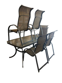 A set of six outdoor patio chairs with dark gray mesh seats and backs, paired with a matching rectangular glass-top table, photographed in a warehouse or furniture store setting.