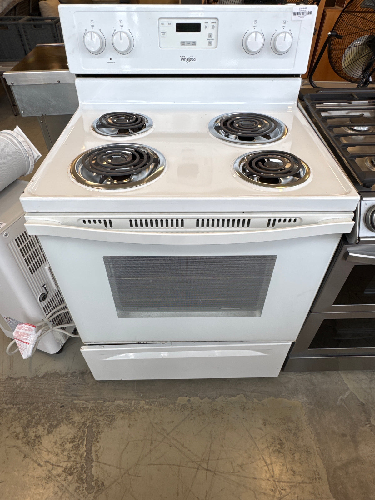 White Whirlpool Freestanding Electric Range Featuring A Four-Coil Burner Cooktop And A Rear Control Console.