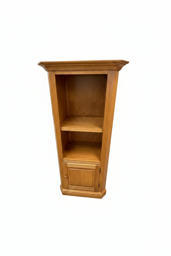 A large wooden writing desk with open shelves and cabinet doors, photographed in a furniture store showroom.