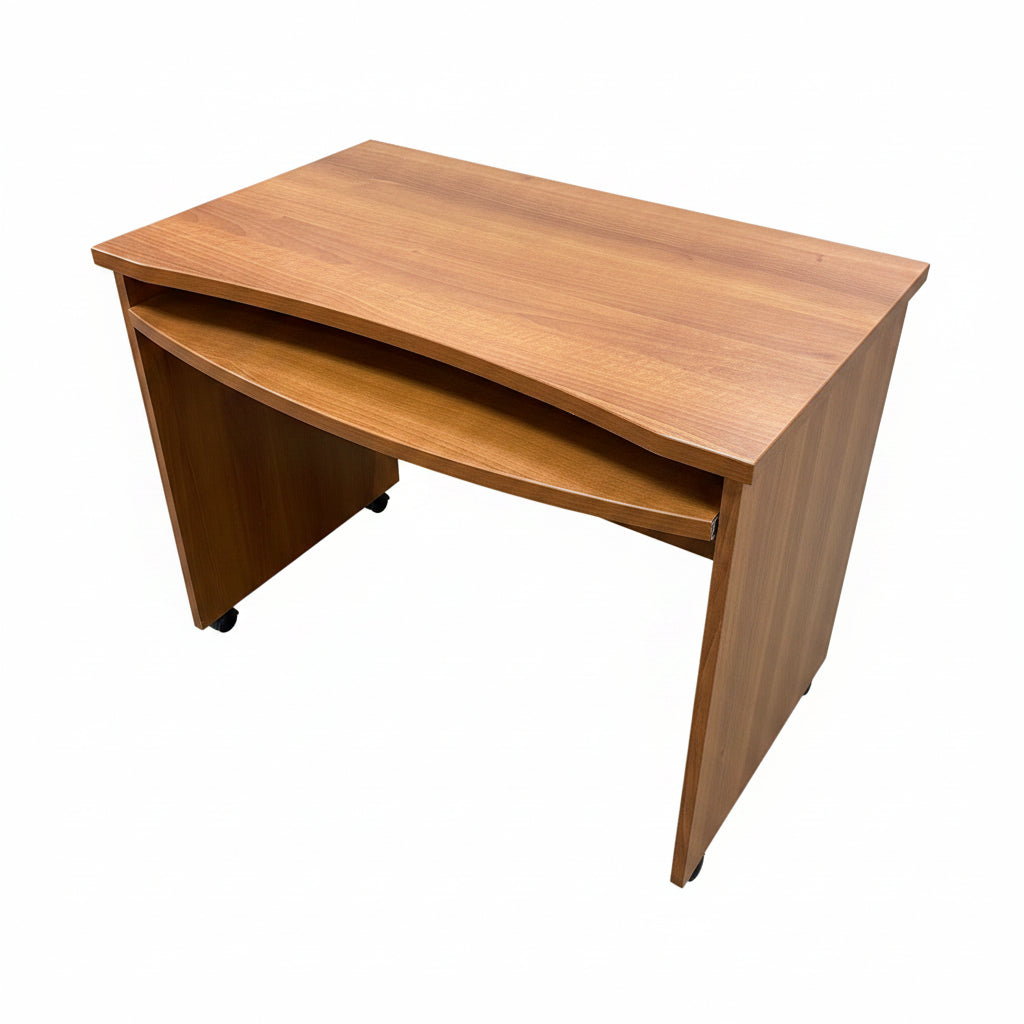 A wooden writing desk with a curved front and open lower cabinet space, shown in a warehouse or showroom setting with concrete floor and wood paneling.