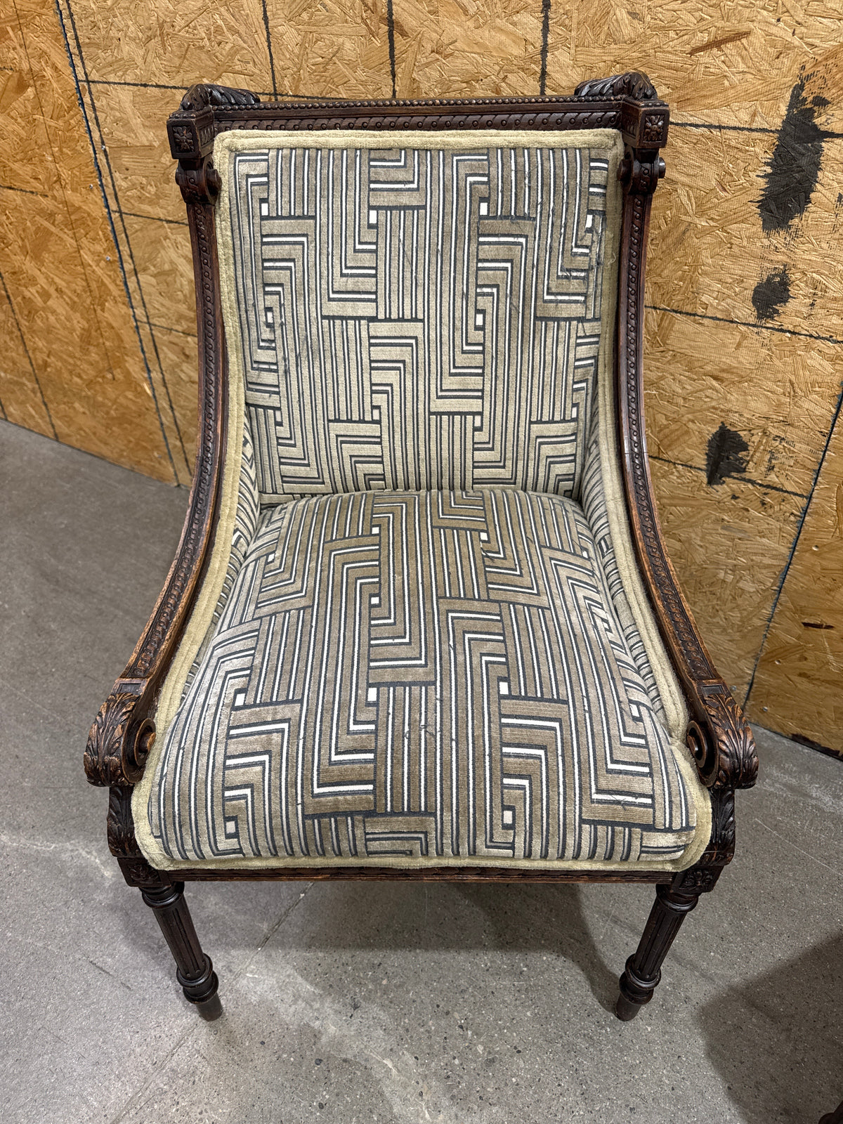Antique French Louis XVI-style Carved Wood Armchair Features a Striking Geometric-Patterned Fabric Upholstery.