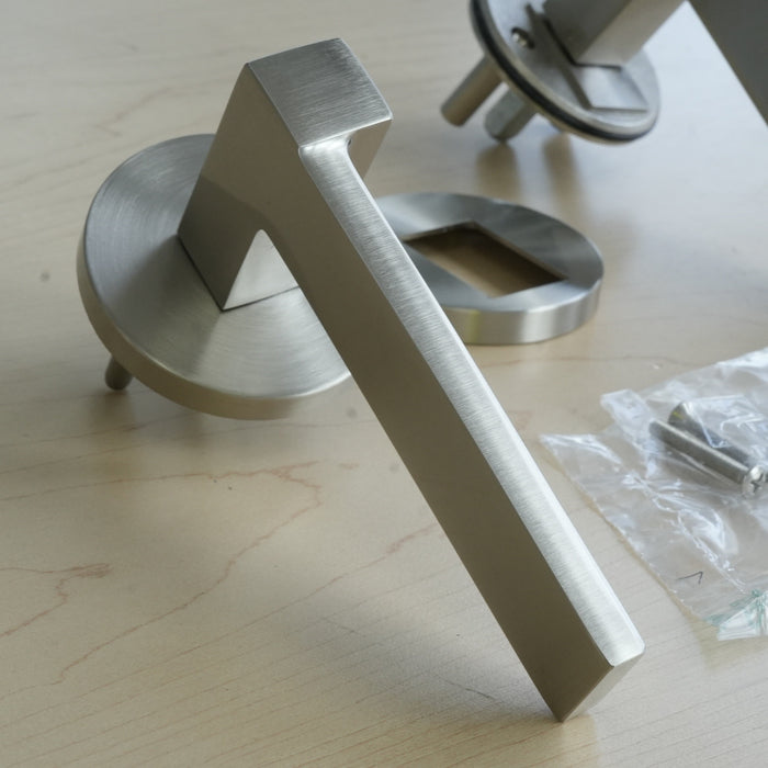 Metallic door handle on a wooden surface with packaging in the background