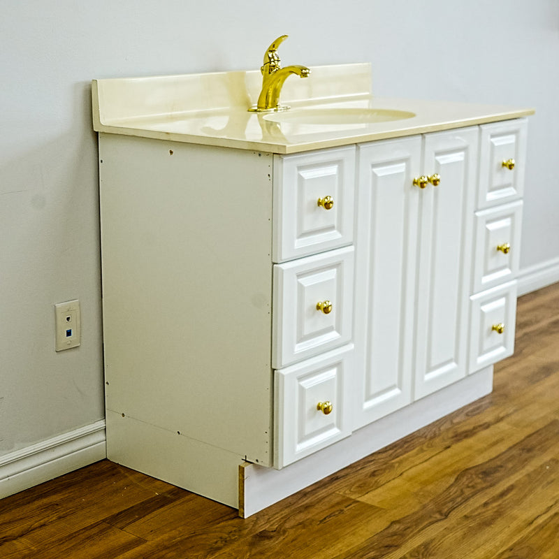 White Bathroom Vanity with Yellow Countertop, Gold Faucet, and Sink