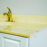 White Bathroom Vanity with Yellow Countertop, Gold Faucet, and Sink