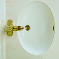 White Bathroom Vanity with Yellow Countertop, Gold Faucet, and Sink