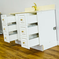 White Bathroom Vanity with Yellow Countertop, Gold Faucet, and Sink