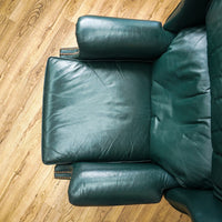Green leather armchair on a wooden floor