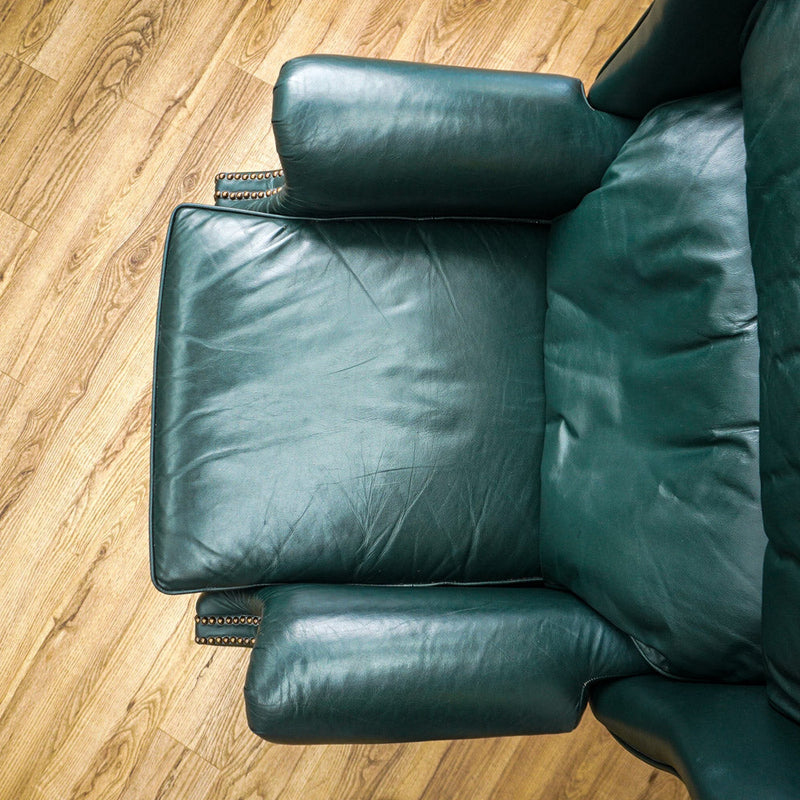 Green leather armchair on a wooden floor
